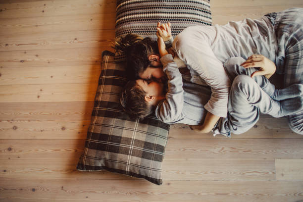 Loving mom tickling her kid on flooring | Allied Flooring & Paint